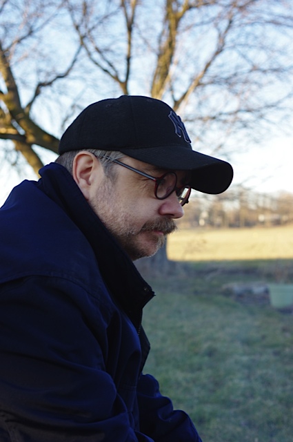 Author Derek Maxfield outside Cemetery Hill at Gettysburg wearing a Yankees ballcap and navy winter coat.